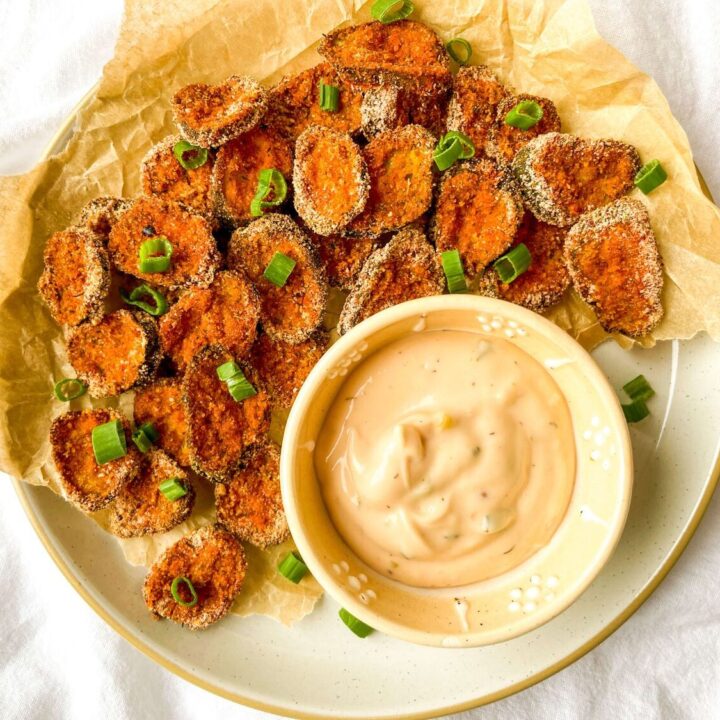 A picture of a platter of pickle chips with dipping sauce.