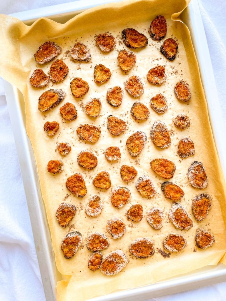 A picture of a set of crispy baked pickle chips in a baking pan.