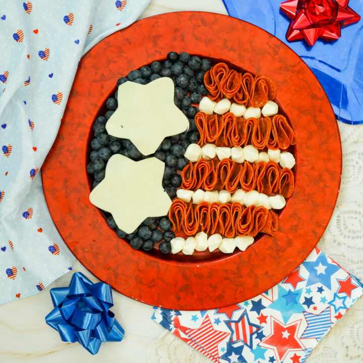 A picture of meats, cheeses, anf fruit arranged to resemble an American flag.