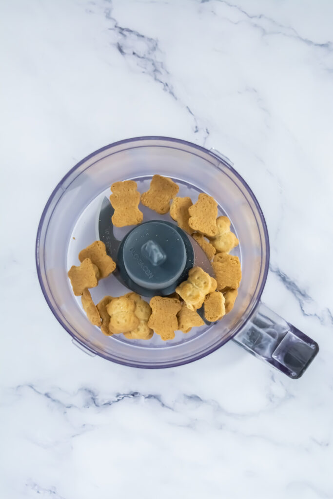 A picture of Teddy Graham cookies in a food processor.