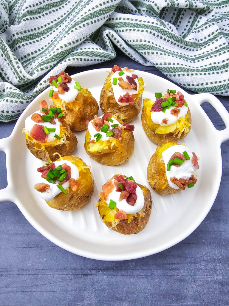 A picture of completed mini loaded baked potato bites on a white serving platter.
