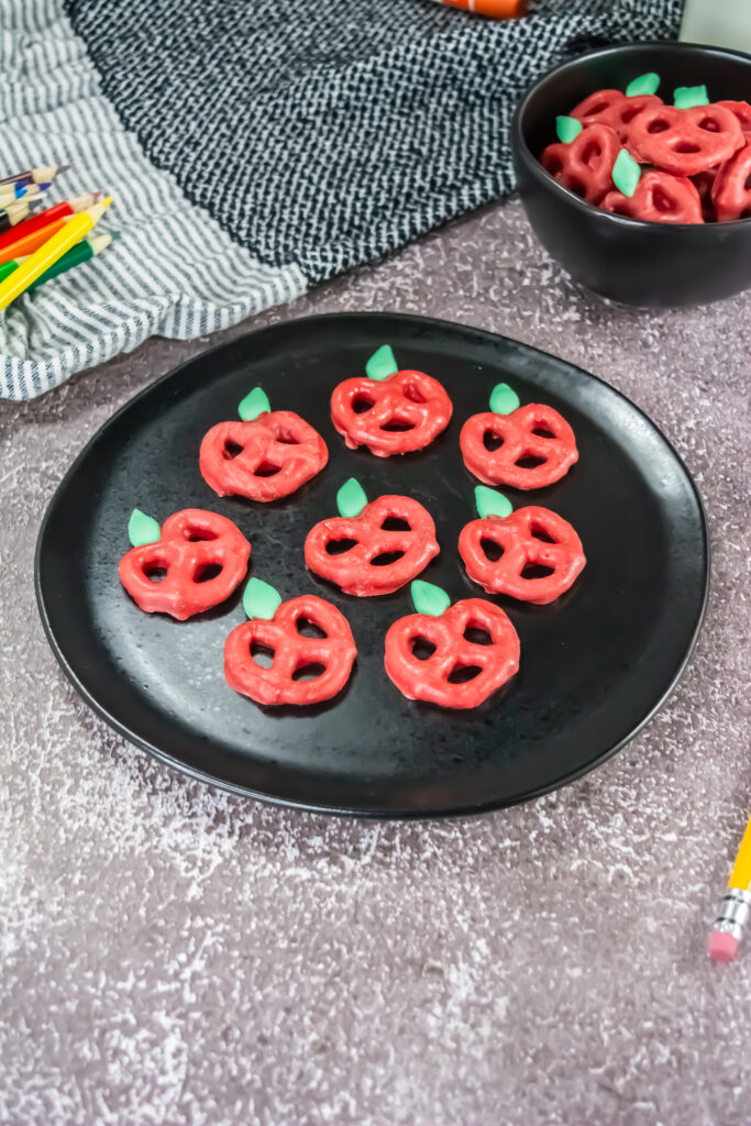 A picture of eight candy coated pretzels on a serving plate. 