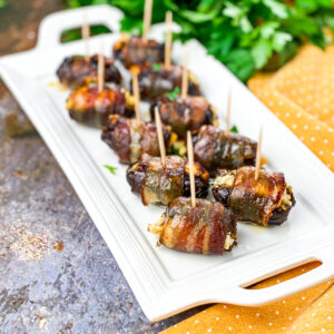 A picture of bacon wrapped dates skewered with toothpicks.