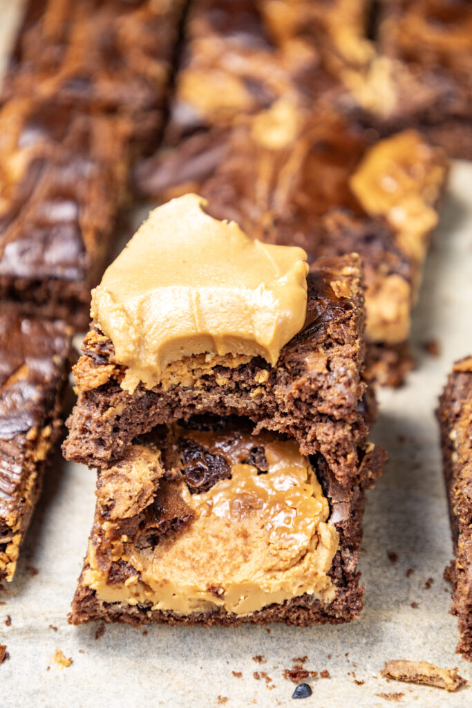 A close up picture of peanut butter brownies with a dollop of peanut butter on top of the center brownie.
