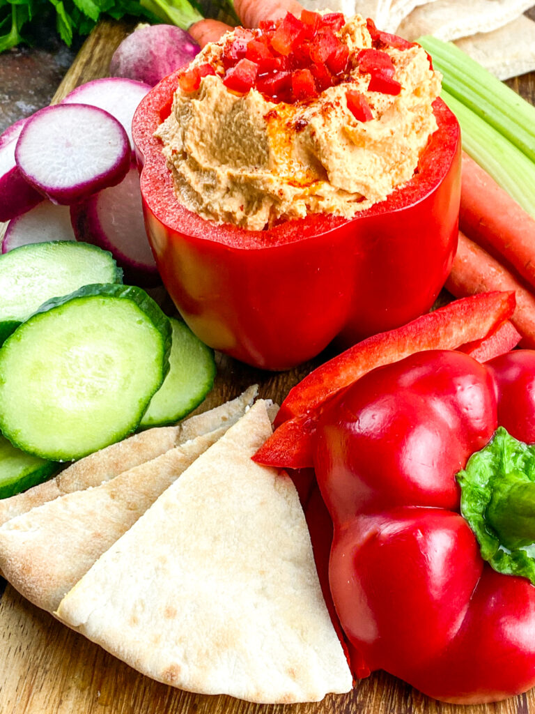 A zoomed in picture of a red bell pepper stuffed with hummus.