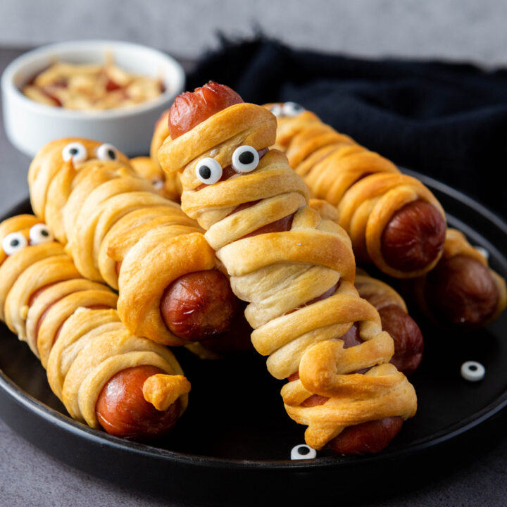A picture of a plate of hot dogs wrapped and fried in crescent roll dough.