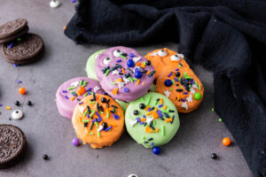 A picture of a small pile of candy dipped oreo cookies.
