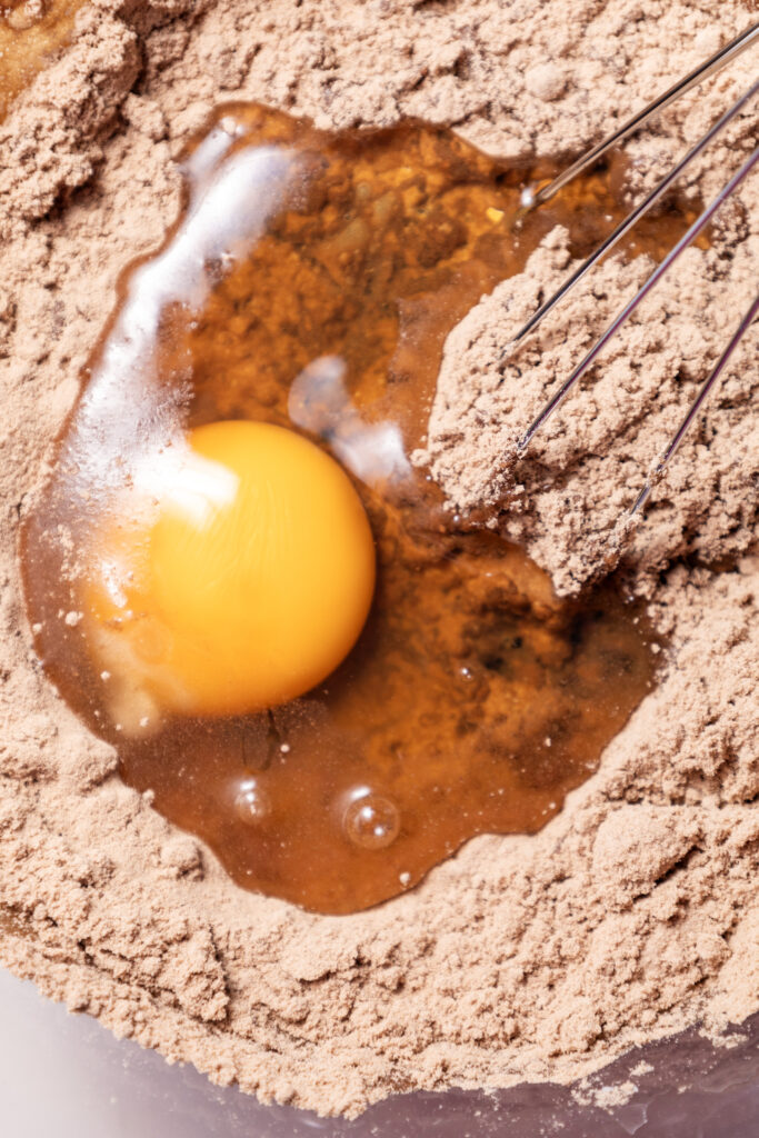 A picture of egg poured into cake mix.