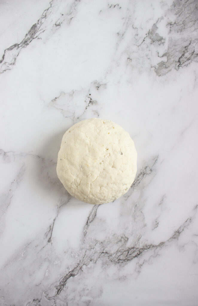 A picture of a large ball of bagel dough.
