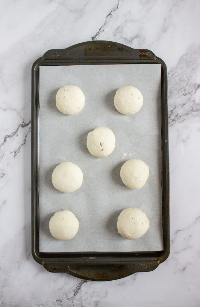 A picture of balls of bagel dough on a baking sheet.