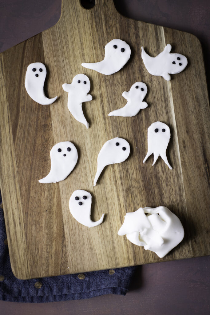 A ppicture of sugar paste ghosts with black eyes.