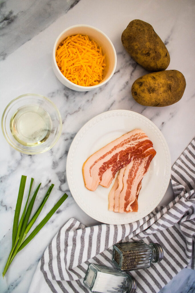 A picture of ingredients needed to make bacon and cheese potato slices.