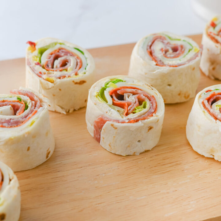 A picture of sliced italian pinwheel sandwiches on a cutting board.
