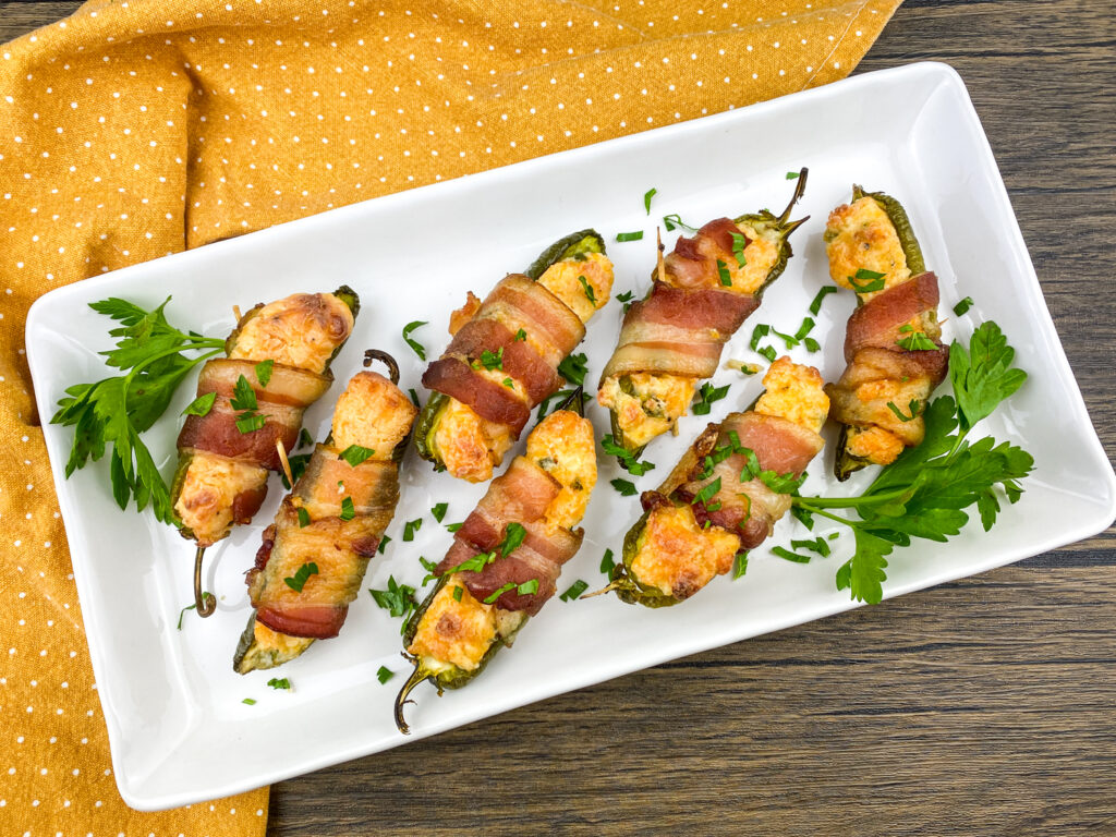 A picture of jalepeno poppers laid out on a white platter.