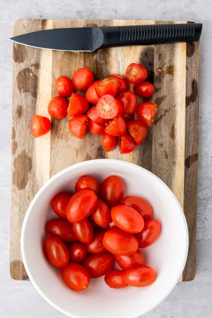 A picture of whole and halved cherry tomatoes.