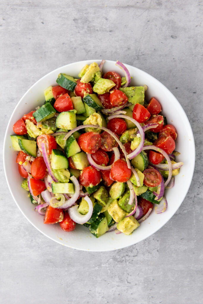 A picture of a bowl of avocado salad seasoned with salt and pepper.
