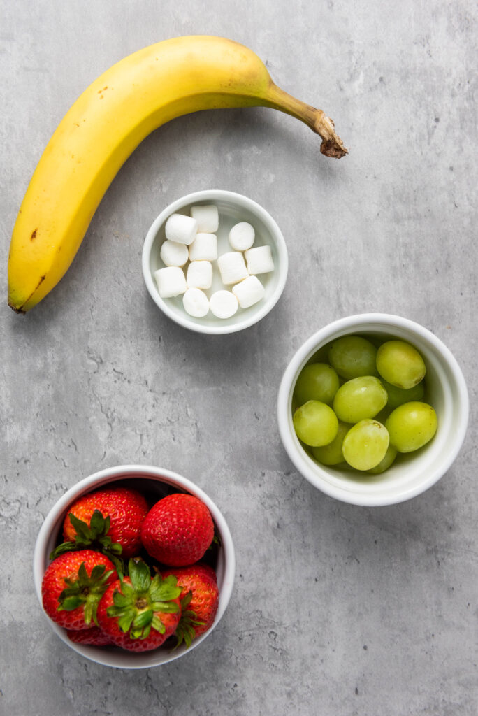 A picture of ingredients needed to make grinch fruit kabobs.