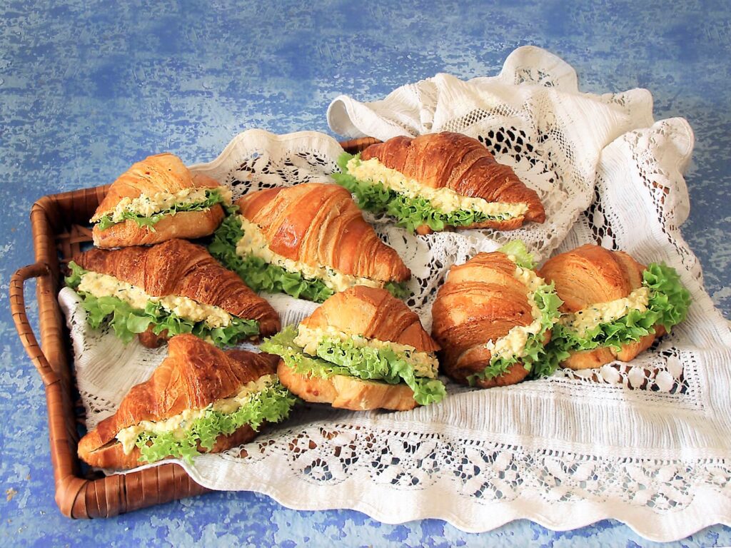 A picture of a platter of croissant egg salad sandwiches.