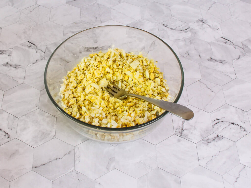 A picture of chopped har boiled eggs in a mixing bowl.