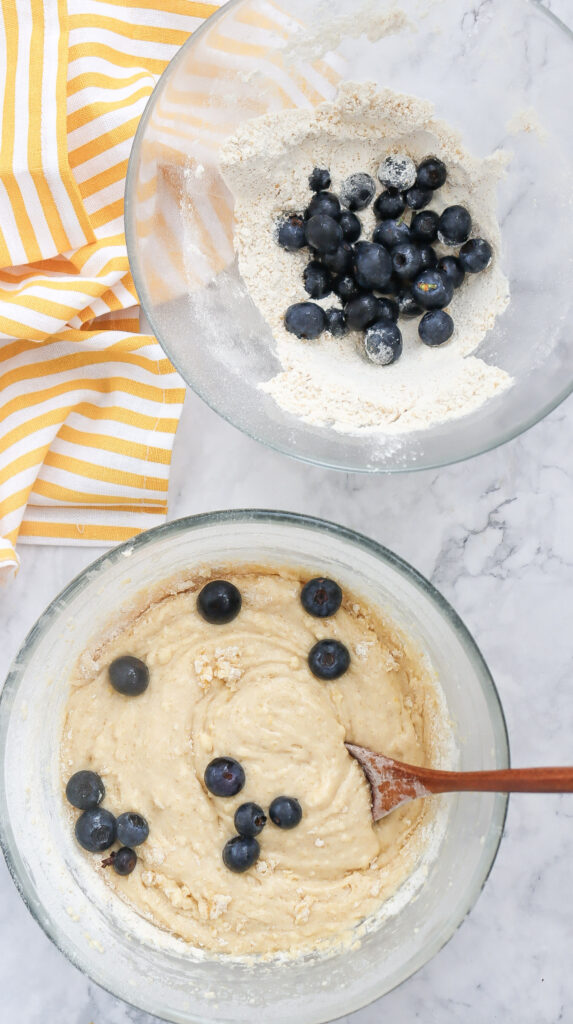 A picture of bundt cake batter in a bowl with blueberries.