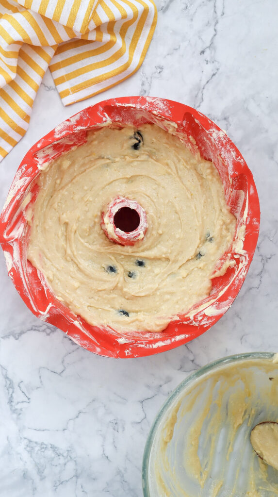 A bowl of bundt cake batter poured into a cake pan.