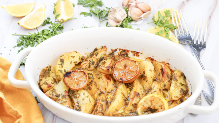 A picture of a serving bowl of lemon greek potatoes.