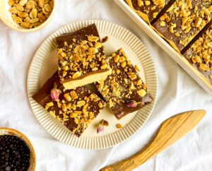 A picture of three peanut butter shorbread cookie bars on a plate with rosebuds.