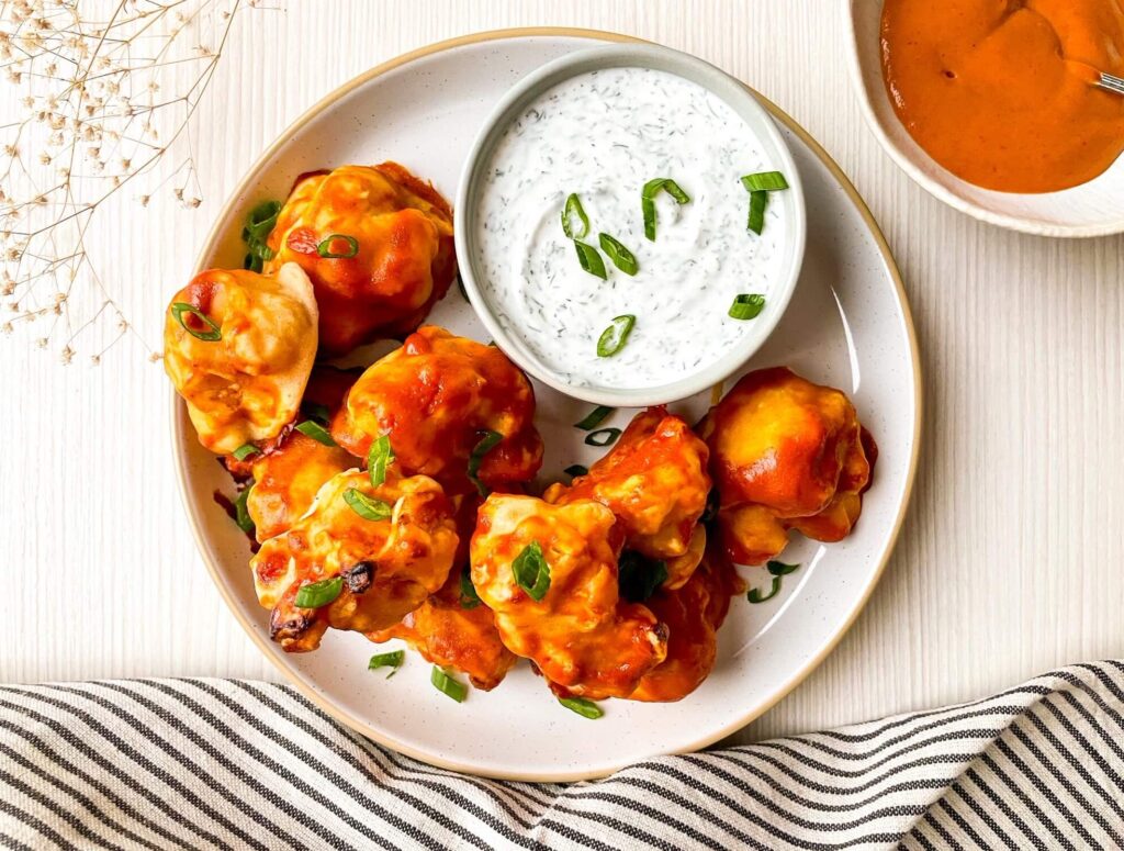 A picture of cauliflower bulbs covered with buffalo sauce.