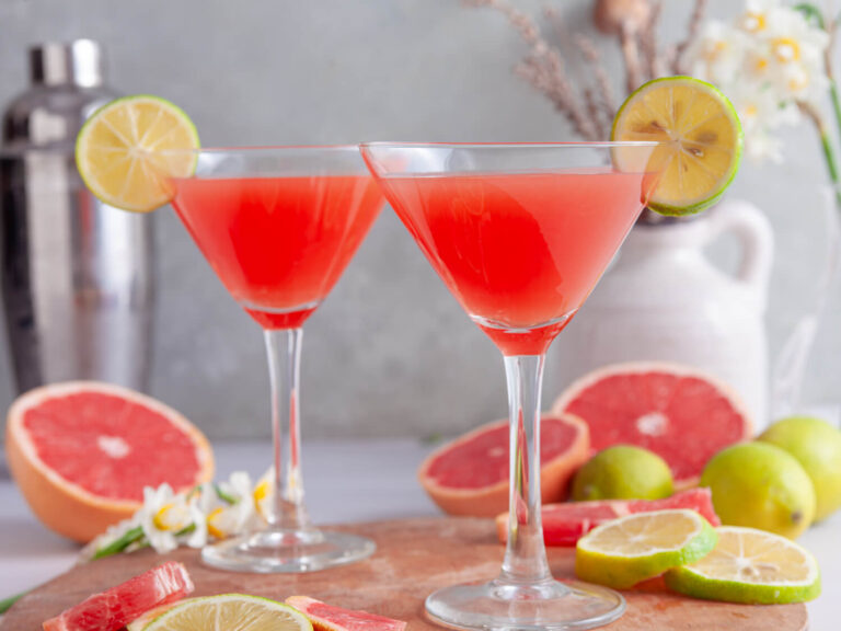 A picture of two pink grapefruit martinis in martini glasses.