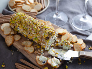 A picture of a pistachio and black currant cheese log.