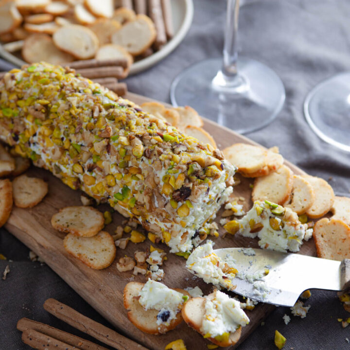 A picture of a pistachio and black currant cheese log.