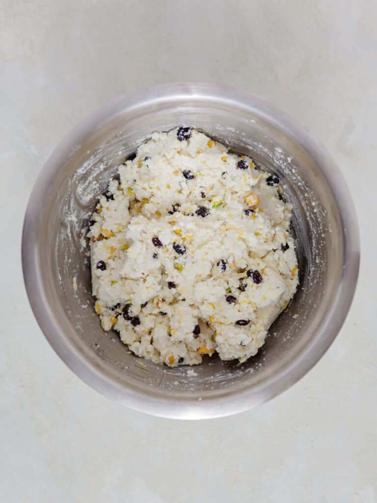 A picture of a pistachio and cheese mixture in a tin bowl.