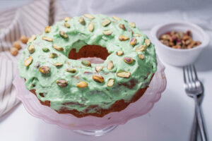 A picture of pistachio bundt cake on a cake stand.