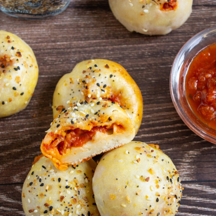 A picture of pepperoni stuffed mini bagels with a bite taken out of one.