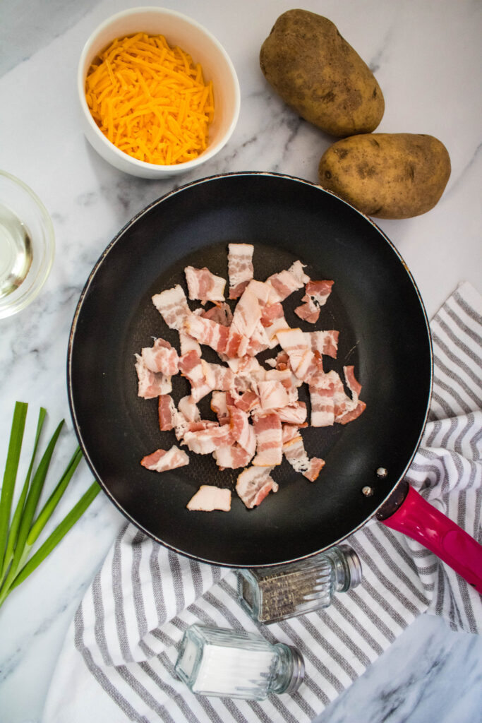 A picture of chopped raw bacon in a skillet.