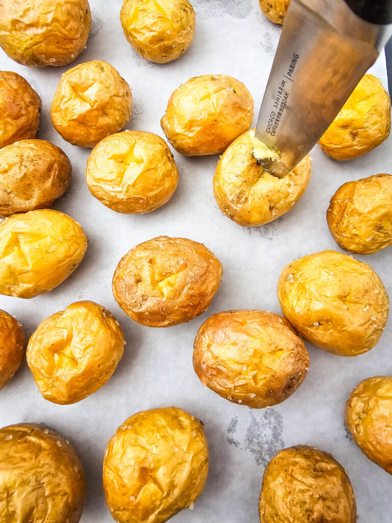 A picture of an X being cut into a cooked mini potato.