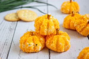 A picture of three pumpkin cheeseballs, with one stacked on top of the other two.