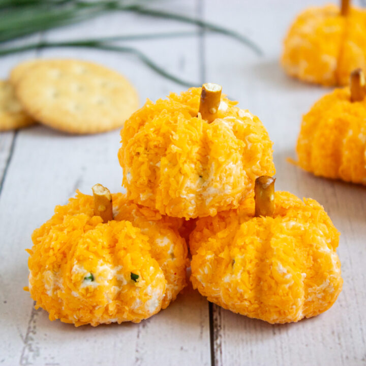 A picture of three pumpkin cheeseballs, with one stacked on top of the other two.