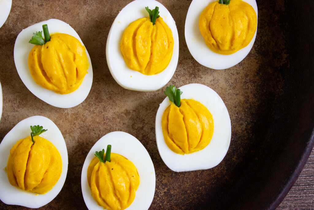 A picture of six pumpkin deviled eggs.