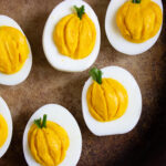 A picture of six pumpkin deviled eggs.