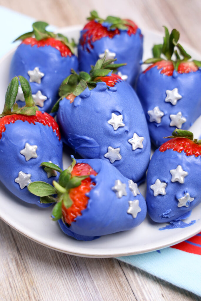 A zoomed in picture of a set of candy coated strawberries.