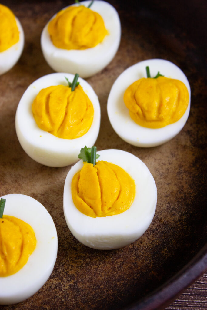 A zoomed in picture of a set of pumpkin deviled eggs.