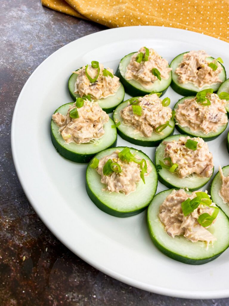 A picture of several cucumbers topped with spicy tuna.