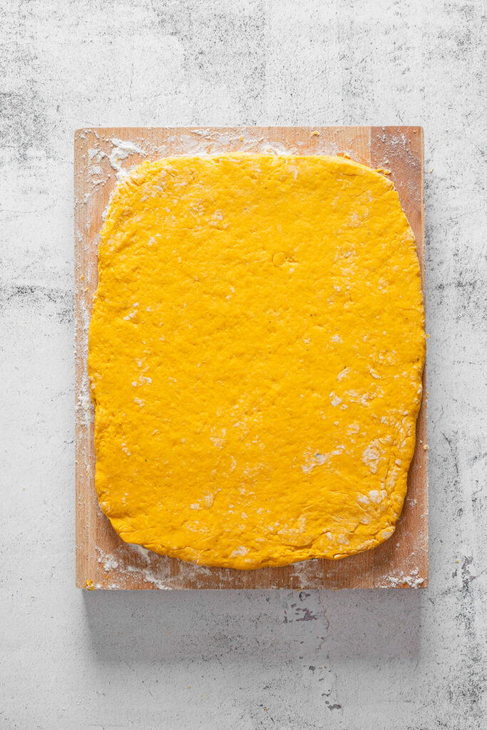 A picture of pumpkin spice scone dough flattened with a rolling pin.
