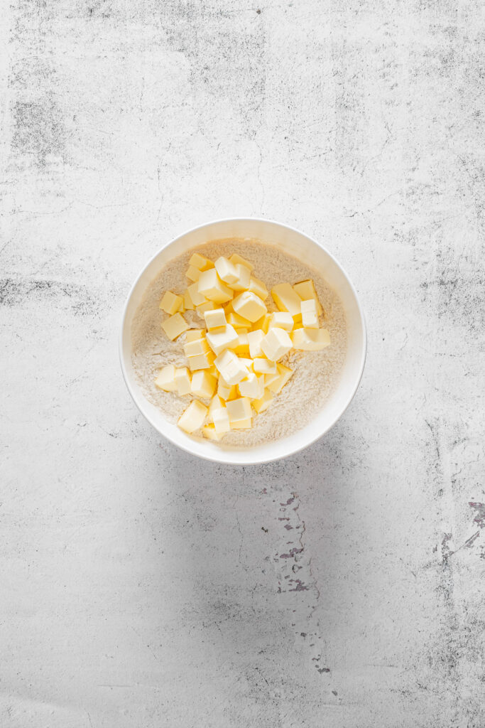 A picture of flour, spices, and cubed butter together in a bowl.