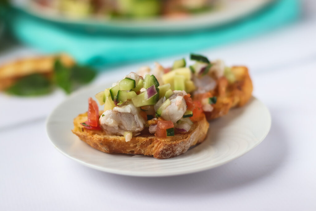 A picture of shrimp ceviche on top of a crostini.