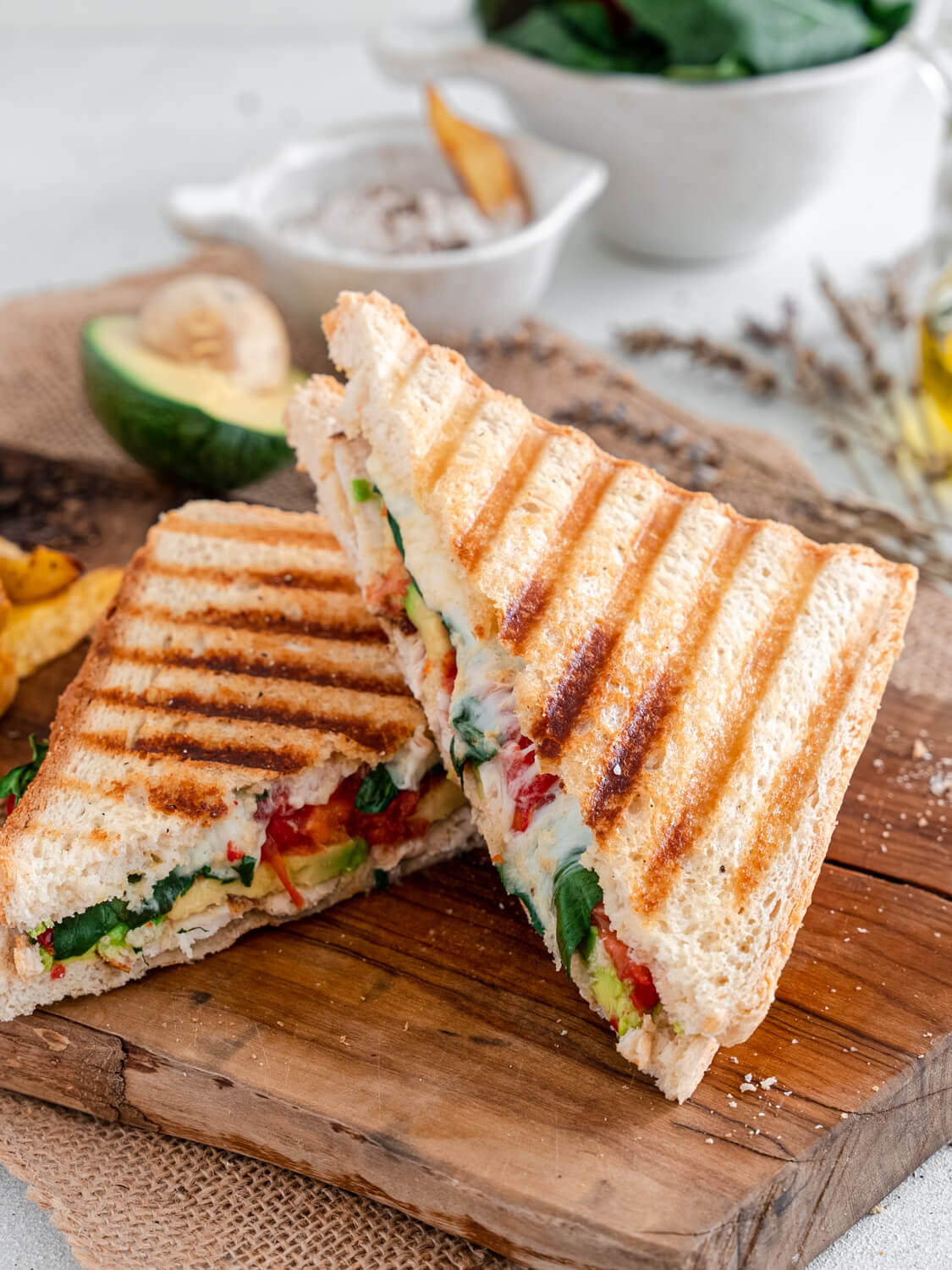 A picture of a toasted, sliced chicken avocado panini.