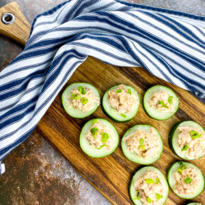 A picture of cucumbers topped with spicy seasoned tuna.