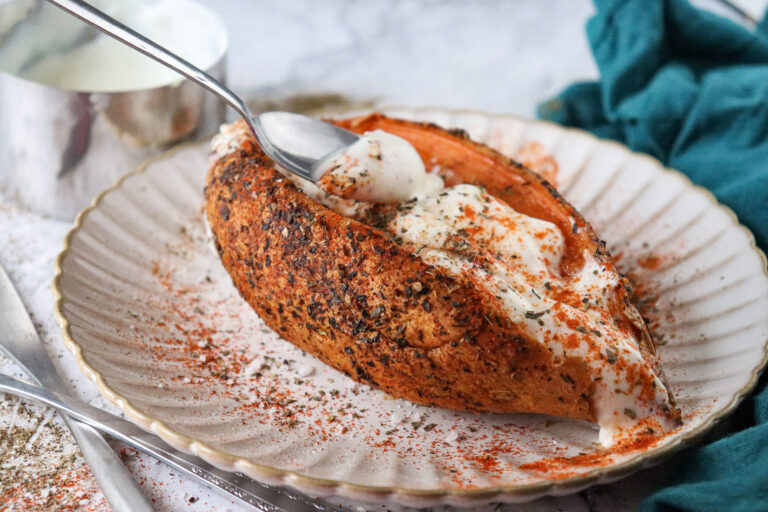 A picture of an air fried sweet potato topped with greek yogurt.