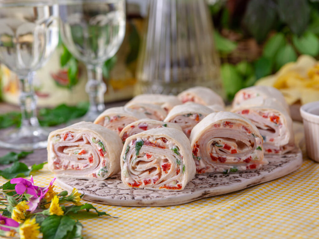 A picture of a platter of turkey tomato pinwheel sandwiches.